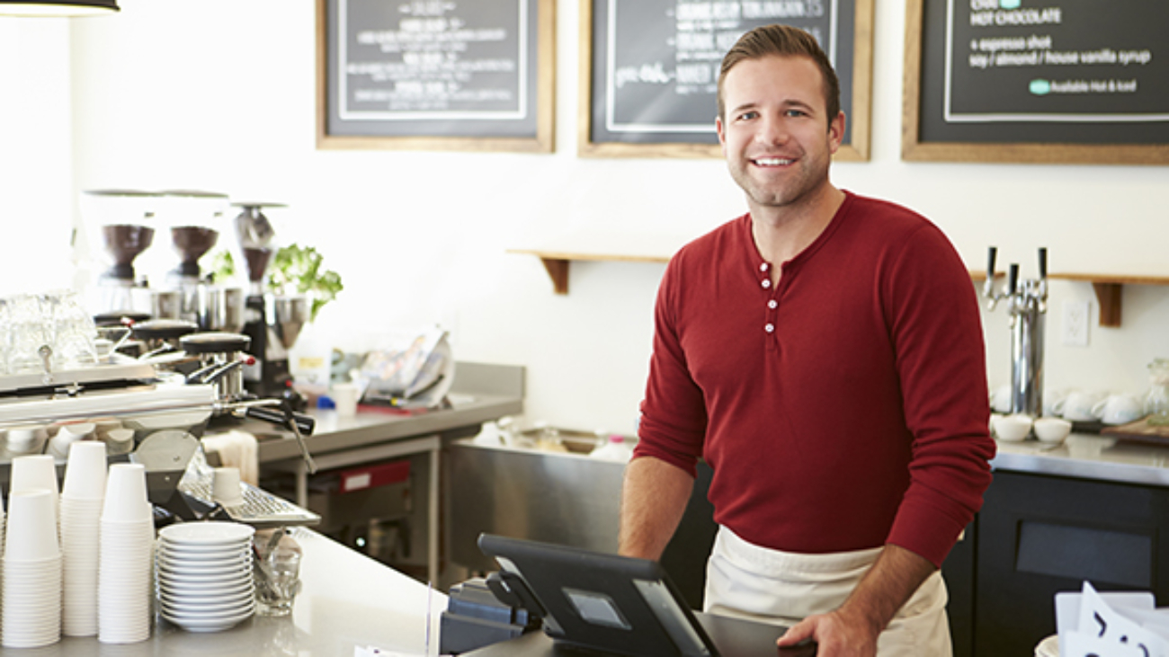 Customer Paying In Coffee Shop Using Touchscreen