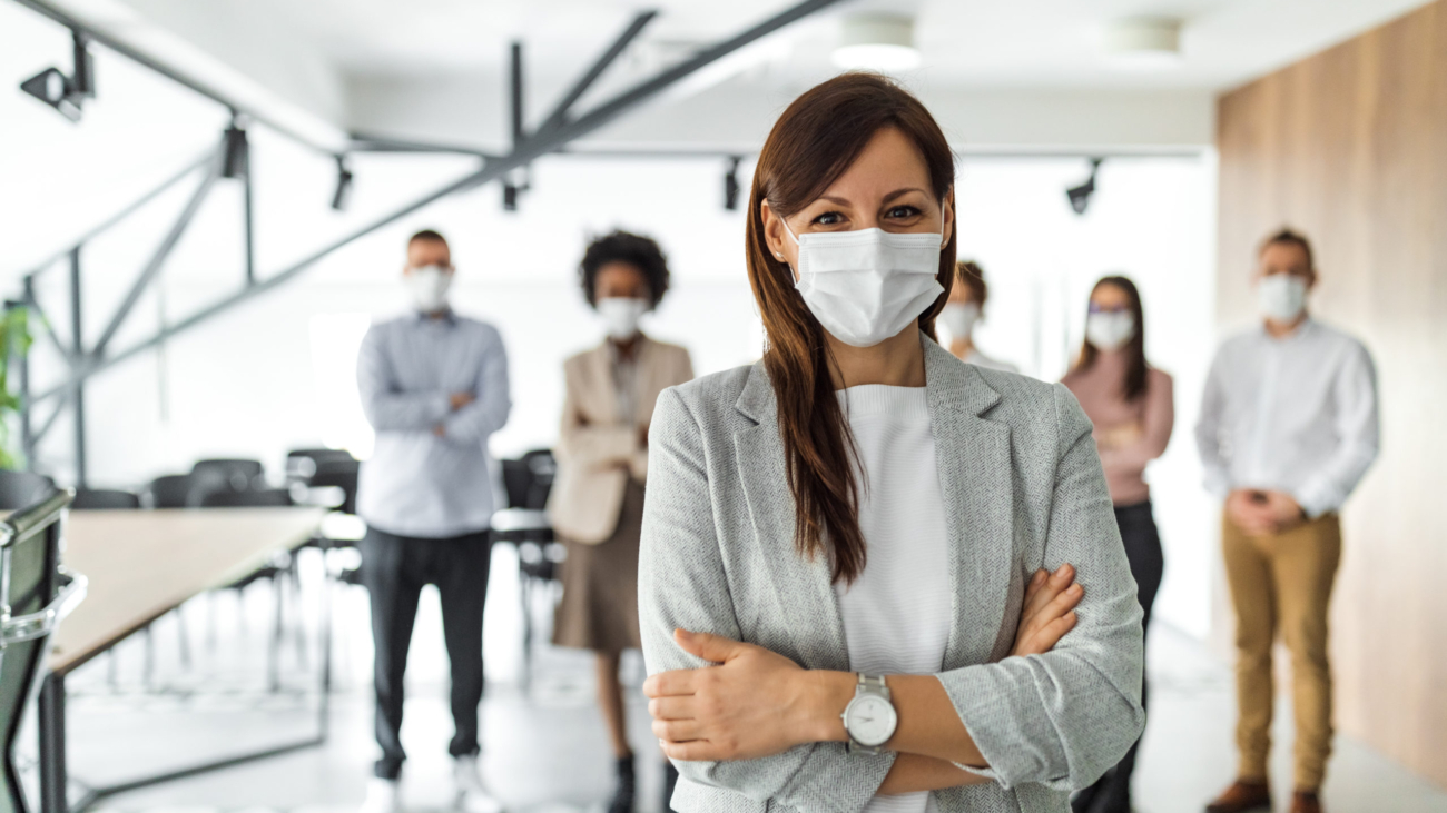 Female leader, protection on the first place, business people in the background.